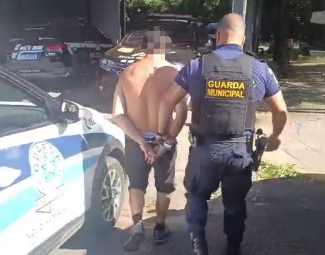 Homem sendo levado por guarda municipal para a delegacia de policia de Novo Hamburgo