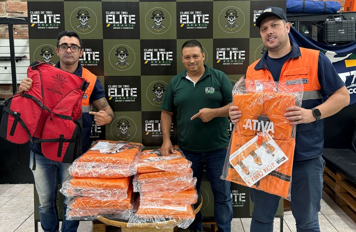 Equipe da Defesa Civil com os coletes doados em mãos