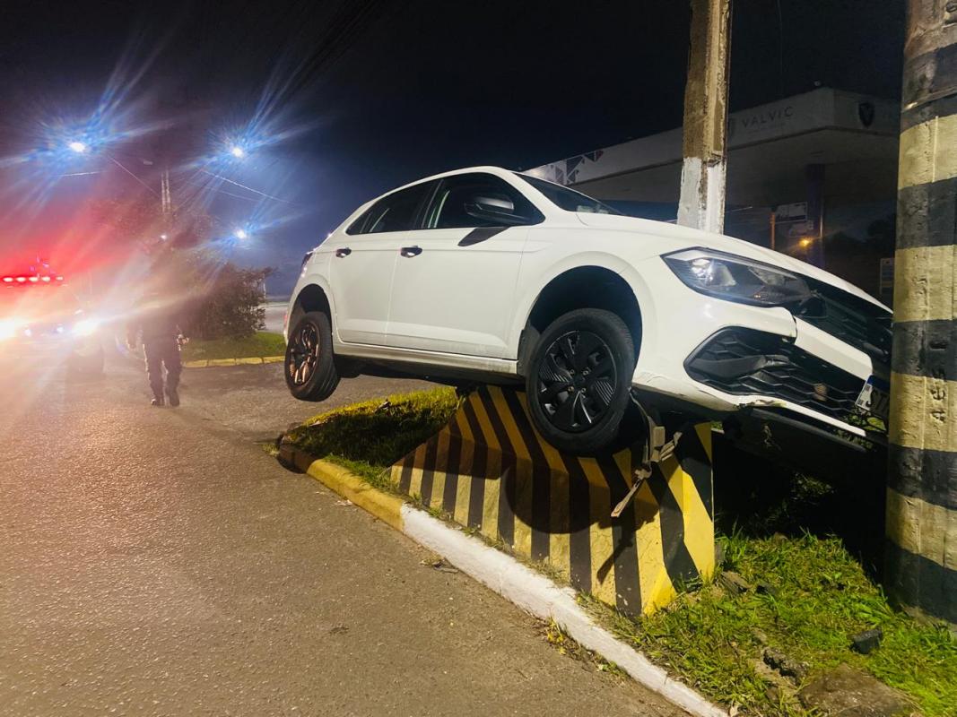 Veículo ficou sobre proteção de concreto no canteiro