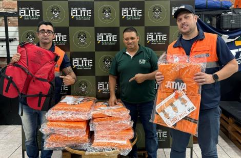 Equipe da Defesa Civil com os coletes doados em mãos